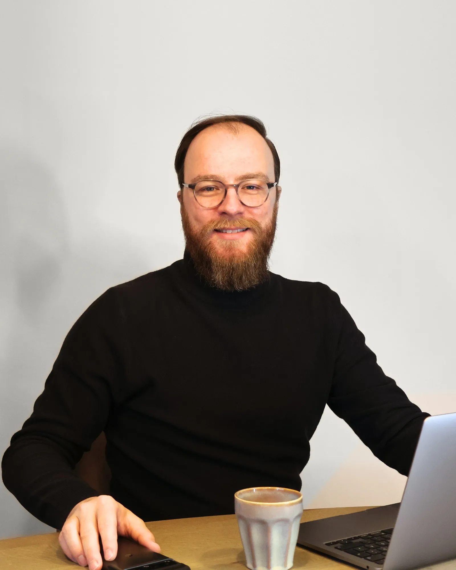Sebastian Weidlich at his desk with a laptop and a cup of coffee